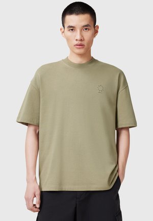 Oliven grøn oversized t-shirt lavet af bomuld. Har en rund halsudskæring, korte ærmer og en lille logo detalje på brystet. Glat tekstur.