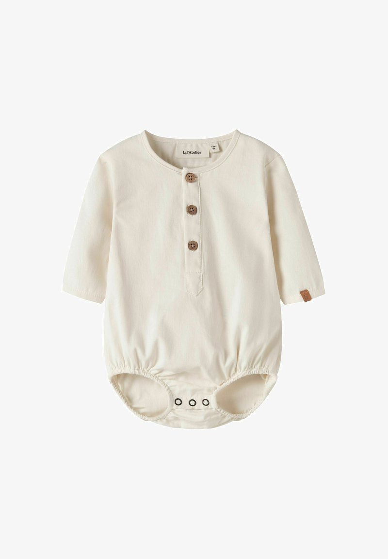 Combinaison bébé couleur crème avec trois boutons marron sur le devant, manches longues et pressions en bas pour un changement facile.
