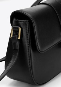 Borsa a tracolla in pelle nera con un design strutturato, caratterizzata da una texture liscia, dettagli in hardware dorato e chiusura a patta piatta.