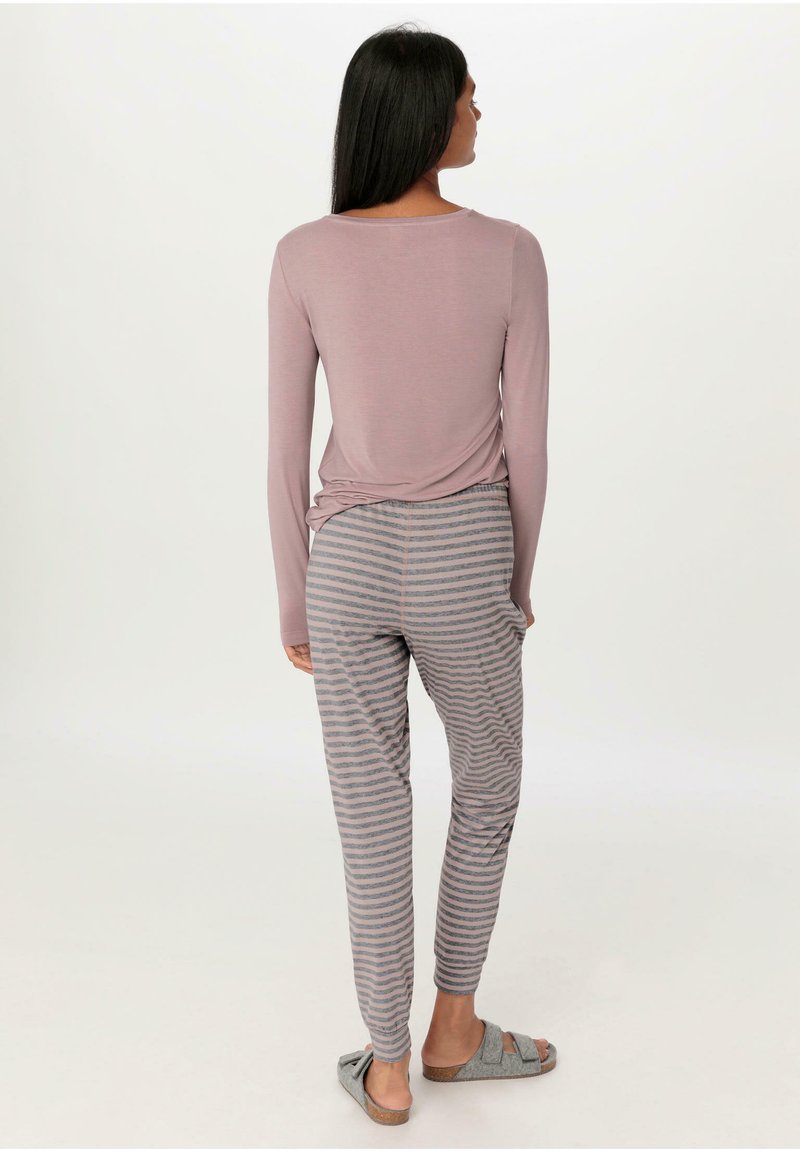 Long-sleeve, mauve top with a relaxed fit, paired with gray-striped lounge pants and gray slip-on slippers, viewed from the back.