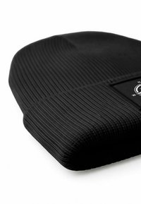 Black ribbed beanie hat with a snug fit, featuring a textured surface and a rectangular black label with a circular logo.