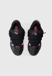 Czarne sneakersy z różowymi akcentami i grubymi czarnymi sznurówkami. Posiadają wyściełany kołnierz, teksturowane boki oraz detale z logo na języku i cholewie.