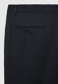 Schwarze, strukturierte Hosen mit einer Gesäßtasche und einer einzelnen Knopfverschluss sowie Gürtelschlaufen, aus gewebtem Stoff gefertigt.