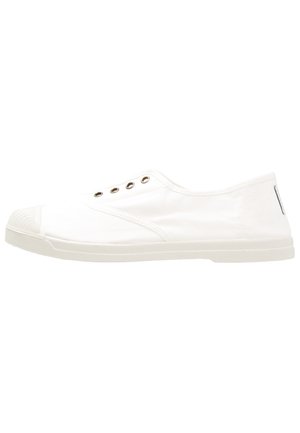 Zapato tipo slip-on de lona blanca con suela de goma, presenta ojales de metal para ventilación, punta redondeada y superficie texturizada.