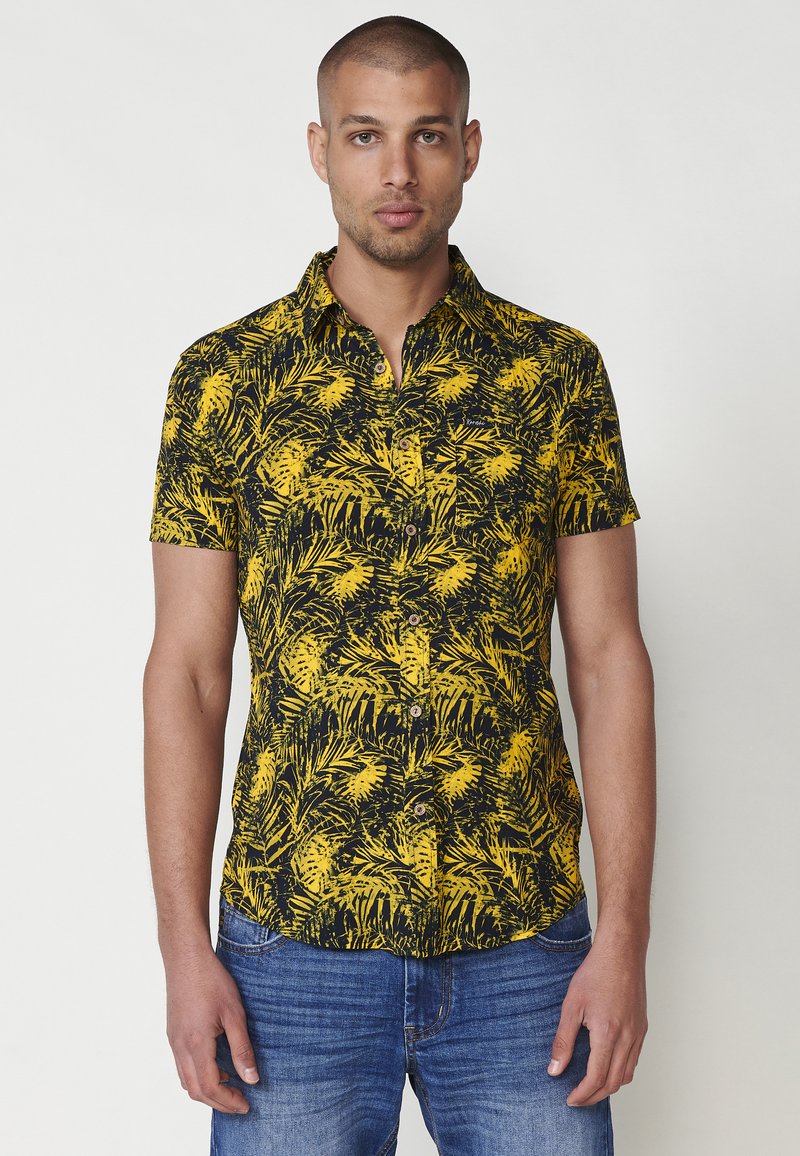 Cămașă cu mâneci scurte, în model floral negru și galben, având un design cu butoniere, guler și o textură a materialului moale.