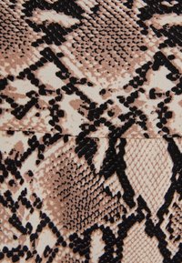 Tessuto con stampa a serpente caratterizzato da una miscela di beige chiaro e marrone scuro, con una superficie texture e un pattern dettagliato.