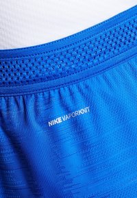 Tela deportiva Nike VaporKnit azul con un diseño texturizado. Cuenta con una cintura de malla y una marca sutil. Material suave y ligero.