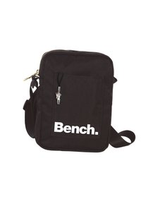 Sac à épaule noir en toile de forme rectangulaire, arborant un grand logo blanc "Bench.", une poche zippée et une bandoulière réglable.