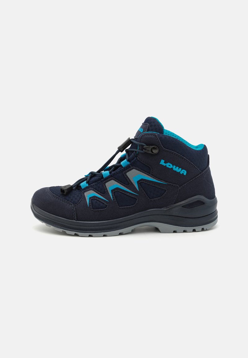 Mittelhohe Wanderschuhe in dunklem Marineblau und Aqua. Ausgestattet mit einem strapazierfähigen Textil-Obermaterial, einem Schnell-Schnürsystem, einem gepolsterten Kragen und einer robusten grauen Sohle.