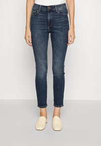 Mörkblå skinny jeans med hög midja, med framfickor, knappstängning och lätt blekning vid knäna.