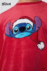 Rode pluche T-shirt met een gestikte afbeelding van een blauwe cartoonfiguur met een kerstmanmuts, opvallende oren en grote, expressieve ogen.