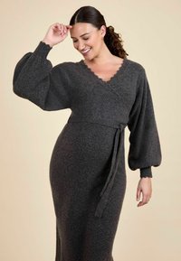 Graues, langärmliges Wickelkleid aus weichem Strickstoff. Mit einem gewellten Ausschnitt, voluminösen Puffärmeln und einem gebundenen Taillendetail.