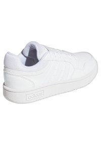 Zapatillas deportivas blancas con exterior de cuero texturizado, acentos de malla, punta redondeada y suela acolchada. Presenta tres franjas laterales.