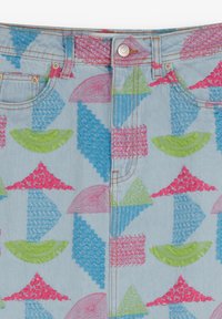 Denim azzurro con motivi geometrici colorati in rosa, verde e blu. Presenta una chiusura a bottone e un design classico a cinque tasche.