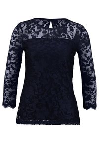 Námořnická modrá krajková halenka s dlouhými rukávy, květinovým vzorem, poloprůhlednou texturou a detailem ve tvaru klíčové dírky na výstřihu. Spodní lem má vlnitý okraj.