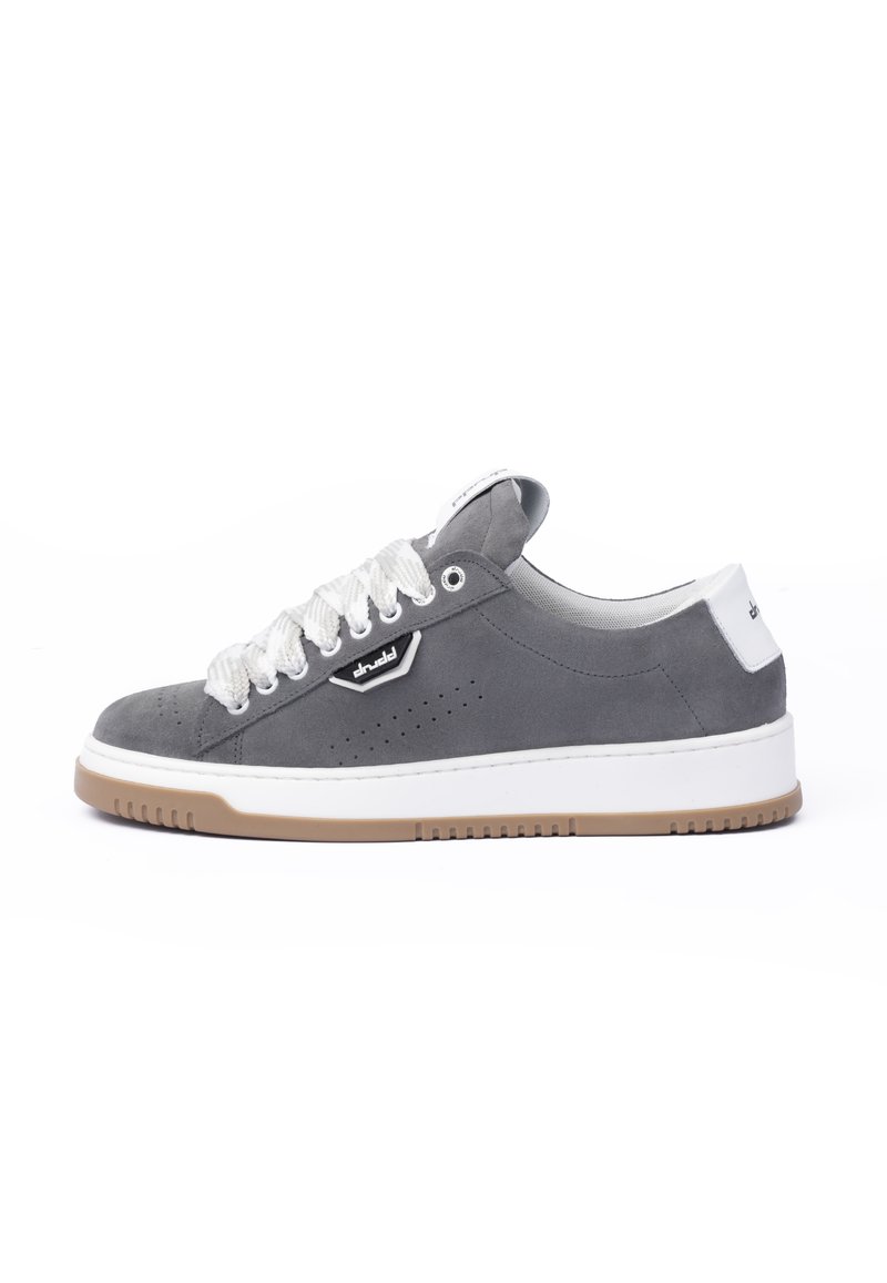 Gray suede sneaker with white rubber sole and laces. Features perforated design on the sides and brand logo on the side, minimalistic style.