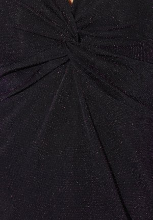 Top de punto negro con un diseño retorcido en el centro, con brillo metálico en todo su superficie y una sutil textura.