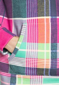 Sudadera a cuadros colorida con tonos rosa, verde y púrpura; tela suave con detalles de bolsillo; puños a rayas y patrones de patchwork variados.