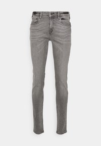 Jeans ajustados en un lavado gris oscuro, con un clásico diseño de cinco bolsillos, lazos para cinturón y una sutil textura descolorida en todo su recorrido.