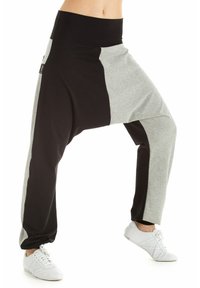 Harem hlače v črni in sivi mešanici bombaža; široka elastična pasnica; ohlapen kroj; kontrastne barve ustvarjajo patchwork učinek.