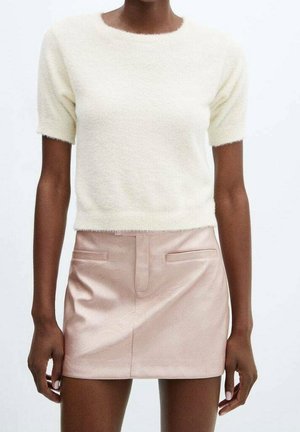 Kremowy, puszysty sweter z krótkim rękawem w połączeniu z dopasowaną różową skórzaną mini spódnicą z dwoma przednimi kieszeniami i gładką fakturą.