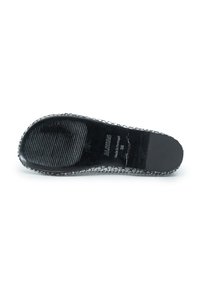 Suola di scarpa in gomma nera con motivi di presa testurizzati, caratterizzata da un bordo rialzato e logo impresso. Finitura liscia e lucida con texture a pelle di serpente.