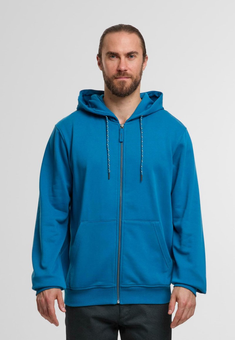 Niebieska bluza z kapturem zapinana na zamek, z regulowanym kapturem, przednimi kieszeniami, miękką teksturą i ściągaczami na rękawach. Zamek błyskawiczny sięga do kołnierza. Prosty design.