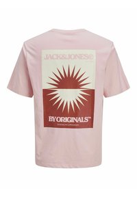 Lyserød bomulds T-shirt med et stort rødt grafisk tryk, der har et solstråledesign og mærkenavn. Korte ærmer og rund hals.