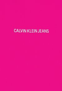 Calvin Klein Jeans-logotypen visas i vit fet stil på en livlig rosa bakgrund, textilmaterial med en slät yta.