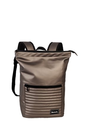 Sac à dos gris matelassé en matériau lisse. Dispose d'un compartiment principal zippé et d'une poche zippée à l'avant avec une texture nervurée. Bretelles noires.