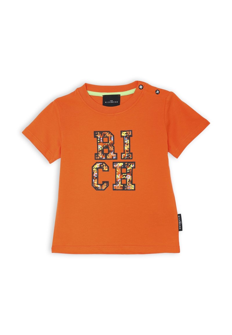 T-shirt arancione a maniche corte in cotone, con una stampa grafica che riporta la scritta "RICH" in lettere multicolori e bottoni a pressione sulla spalla.