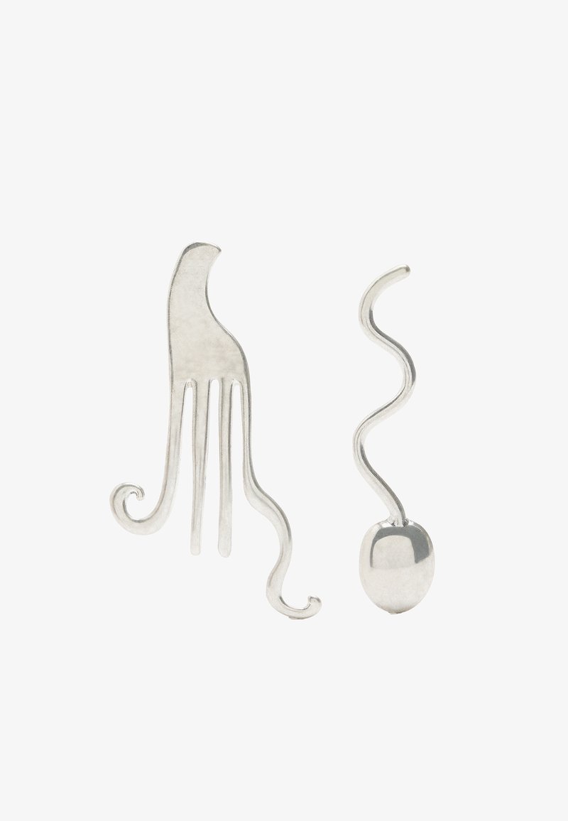 Srebrne kolczyki o abstrakcyjnych, falistych kształtach; jeden ma zakrzywioną, widełkowatą formę, a drugi jest spiralą z gładką, owalną podstawą.