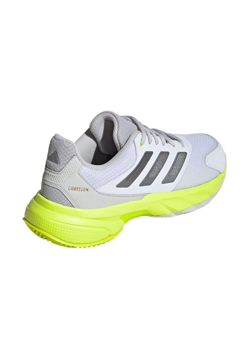 Zapatilla de malla gris con una base blanca, suela verde lima y tres franjas gris oscuro. Cuenta con un cuello acolchado y acentos texturizados.