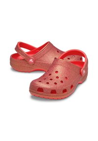 Red glittery clogs with ventilation holes, rounded design, and adjustable heel strap. Made of lightweight material with a textured finish.