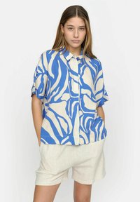 Camicia a maniche corte con bottoni in blu e crema con un audace motivo astratto. Realizzata in tessuto leggero, presenta una vestibilità rilassata e colletto.