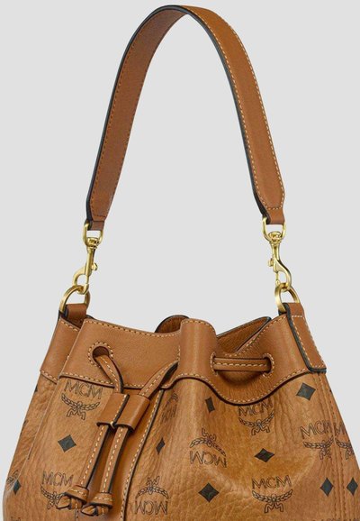 Bruine leren MCM emmerhandtas met logopatroon, verstelbare band en gouden metalen accenten op een lichte achtergrond.
