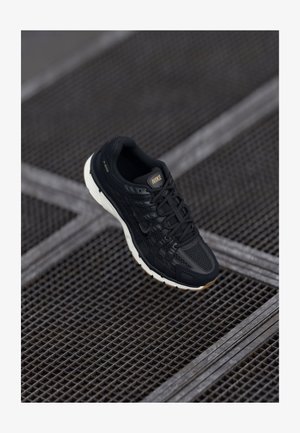 Schwarzer Nike-Laufschuh mit strukturiertem Mesh-Obermaterial, Gummisohle und dezenten goldenen Akzenten. Verfügt über ein Schnürdesign und eine gepolsterte Sohle.