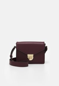 Borsa a tracolla in pelle bordeaux con una chiusura circolare dorata, caratterizzata da un design strutturato, tracolla regolabile e accenti minimalisti.