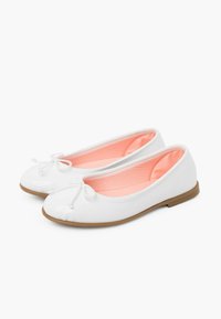 Ballerine in pelle lucida bianca con punta rotonda, bordi scanalati e interno rosa. Presentano un fiocco decorativo nella parte anteriore e una suola piatta color tan.