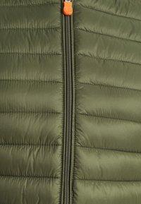 Olivengrøn puffervest med lodret syning, lynlås foran og lys orange lynlåstrækker. Glat, letvævet stoftekstur.