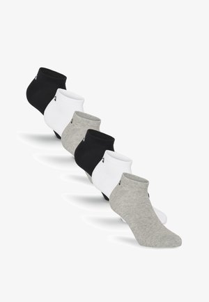 Sechs Paar Knöchelsocken in Schwarz, Weiß und Grau, diagonal auf weißem Hintergrund angeordnet.
