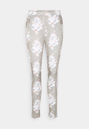 Pantalones ajustados de color gris claro con estampado floral blanco y naranja, bolsillos delanteros con cremallera y rayas blancas laterales.