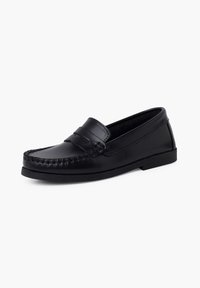 Juodos odinės loafers tipo bateliai su nertomis kojų dalimis ir plokščiu padu. Lygi tekstūra, klasikinė silueto forma ir minimalūs metaliniai elementai.