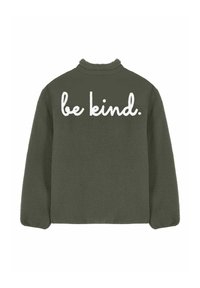 Veste en polaire vert olive avec un col montant et un texte manuscrit blanc "be kind." sur le haut du dos.