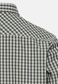 Kurzarmhemd mit einem schwarz-weißen Karomuster. Der Stoff ist aus Baumwolle mit einer glatten Textur und einem klassischen Kragendesign.