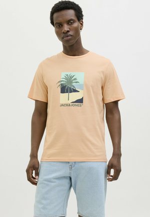 Camiseta de manga corta en color durazno claro con un gráfico de palmera y el texto "JACK & JONES" en la parte inferior. Corte clásico, hecha de material de algodón.