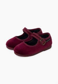 Zapatos Mary Jane de terciopelo burdeos con punta redonda y una sola correa que presenta una hebilla de latón. Interior suave de color negro y suela plana.