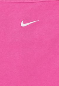 Rosa Nike tanktop med ribbat mönster, prydd med en liten vit swoosh-logotyp på framsidan. Enkel, ärmlös design.
