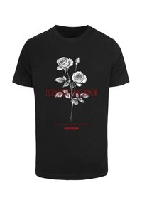 Černé tričko s grafikou dvou podrobných bílých růží se zelenými listy a červeným textem "IRON ROSE" a "RISE STRONG."