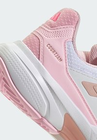 Light pink athletic shoe with mesh and synthetic materials, featuring a textured heel, white sole, and "COURT JAM" embossed detail.